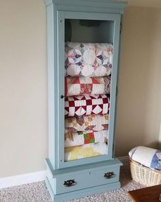 a blue armoire with quilts on it