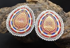 Beautifully hand beaded teardrop shaped 2 1/2 inch x 2 inch hook earrings. shiny golden center surrounded by rows of beautifully rows of red, white, blue, and gold Czech glass seed beads.  Hypoallergenic hooks. Genuine leather backing.  These come gift-ready in carboard Kraft jewelry box with descriptive card as shown. These amazing earrings were handcrafted for Creator's Place a Pine Point tribal artisan living on the White Earth Nation reservation Northern Minnesota. Teardrop Earrings With Dangling Beads, Gold Teardrop Earrings With Colorful Beads, Handmade Teardrop Beaded Festival Earrings, Handmade Teardrop Beaded Earrings For Festivals, Festival Teardrop Earrings With Ear Wire, Traditional Silver Teardrop Beaded Earrings, Gift Teardrop Earrings With Colorful Beads, Festival Teardrop Earrings, Traditional Teardrop Beaded Jewelry