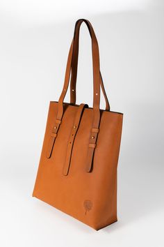 Meet the Cognac Eco-Leather Shoulder Bag. Featuring two leather adjustable straps for best possible fit and leather that is tanned and processed with plant-based materials and dyes versus hazardous chemicals like formaldehyde. Top opening has a zipper closure with a fold-over functioning accent tab. On the interior, you'll find a zippered pocket on the back side and one interior slip pocket large enough to fit a smartphone. The interior cotton lining is rust orange and matches the color of the l Chain Scarf, Candle Wall Decor, Cuff Rings, Accessories Bags Purses, Rust Orange, Tea Accessories, Accessories Storage, Corporate Gifts, Cognac