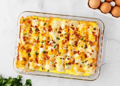 a casserole dish with eggs and bacon on the side, next to a bowl of parsley