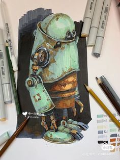 a drawing of a green robot on top of a piece of paper next to markers and pencils