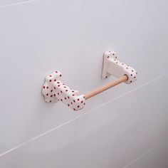 a white door handle with red polka dots on it and a wooden stick sticking out of the handle