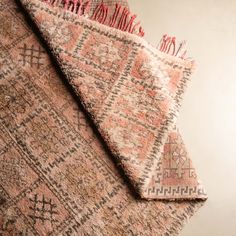 two pieces of pink and brown rugs on top of each other