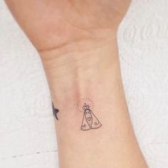 a small tattoo on the wrist of a woman with a cone and star in it