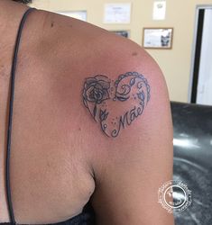 a woman with a tattoo on her shoulder that says love and two roses in the shape of a heart