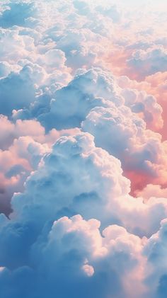 the sky is filled with fluffy clouds and pink hues in this photo taken from an airplane