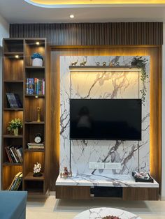 a living room with bookshelves and a flat screen tv mounted on the wall