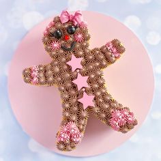 a pink plate topped with a brown and pink decorated teddy bear