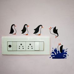 four penguins are standing on the light switch