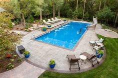 an outdoor swimming pool surrounded by lawn furniture