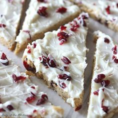 several pieces of cake with white frosting and cranberries