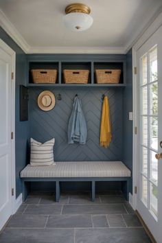 a bench with two baskets on it and a coat rack in the corner next to it