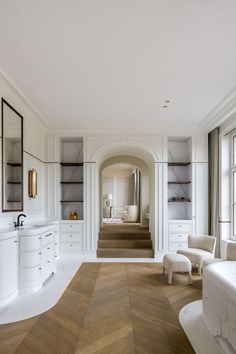 an elegant bathroom with white furniture and wood flooring is pictured in this image from the front view