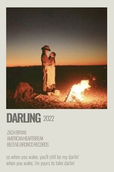 a man and woman standing next to a campfire with the caption darling