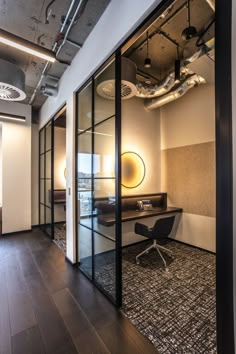 an office with glass walls and wooden floors