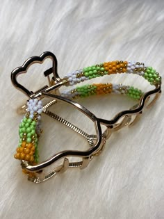 two bracelets made out of different colored beads on a white furnishing area