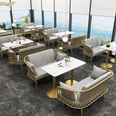 a restaurant with tables, chairs and umbrellas overlooking the ocean