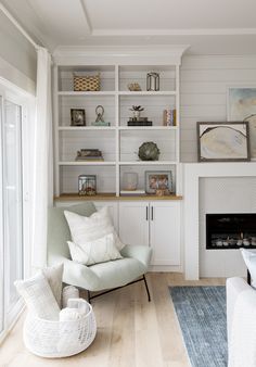 a living room filled with furniture and a fire place next to a wall mounted book shelf