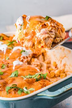 a casserole dish with meat and cheese being lifted from the casserole