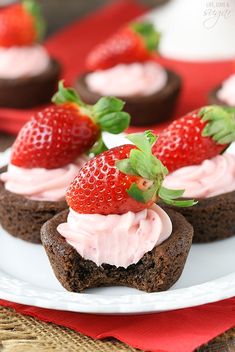 chocolate cupcakes with strawberry frosting and fresh strawberries on top are ready to be eaten