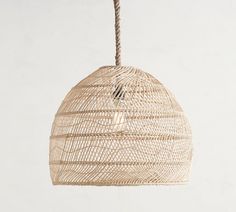 a rattan light hanging from a rope