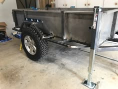 a trailer with wheels is parked in a garage