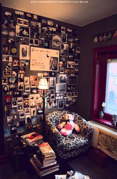 a living room filled with furniture and lots of pictures on the wall behind a window