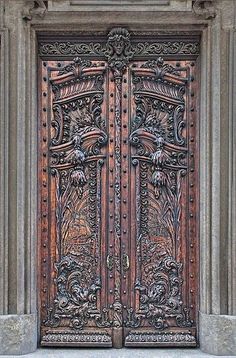 an ornate wooden door with intricate carvings on the front and side panels, in stone