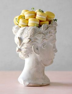 a white statue with some yellow cookies in it's head