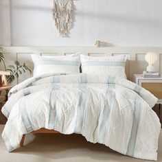 a bed with white and blue comforters in a bedroom