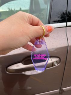 a person is holding a keychain in front of a car with the door open