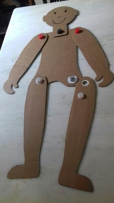 a cardboard cut out of a man with buttons on his chest and legs, sitting on top of a table