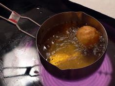 a frying pan filled with food on top of a burner oven next to a spatula