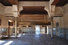 an empty room with tiled walls and columns