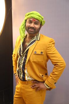 a man in a yellow suit and green turban