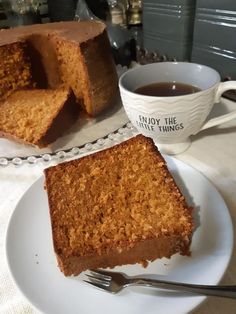 a piece of cake on a plate next to a cup of coffee