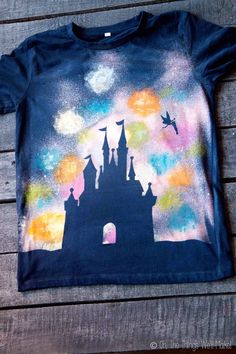 a t - shirt with an image of a castle painted on the front and back