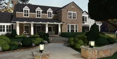 a large house with bushes and lights in the front yard