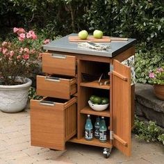 an outdoor kitchen cart with drawers and cutting board