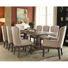 a dining room table with beige chairs and a white rug on the floor in front of it