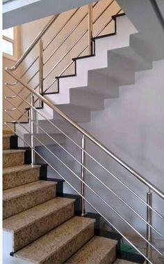 some stairs and railings in a room with carpeted flooring on the ground