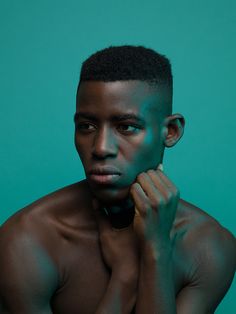 a young man is posing with his hands on his face