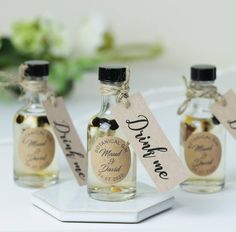 three small bottles with labels on them sitting on a table