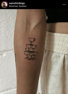 a woman's arm with a tattoo on it and a wine glass in the middle