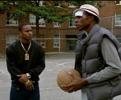 two men standing on a basketball court with one holding a ball