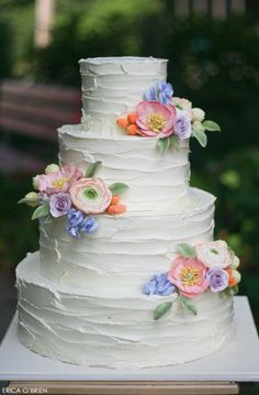 a white wedding cake with flowers on it