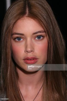 a model with long hair and blue eyes poses for the camera