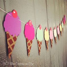 paper ice cream cones are hanging on a line