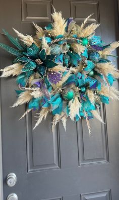 a wreath is hanging on the front door with feathers and flowers around it, as well as other decorations