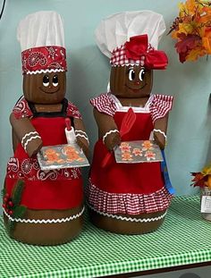 two large brown gingerbread men are standing next to each other on a green and white checkered tablecloth